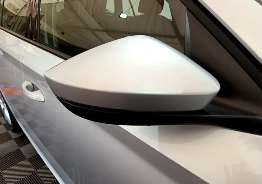 Rétroviseur côté gauche gris clair du Skoda Kamiq 2022, vue rapprochée avec poignée de porte visible.
