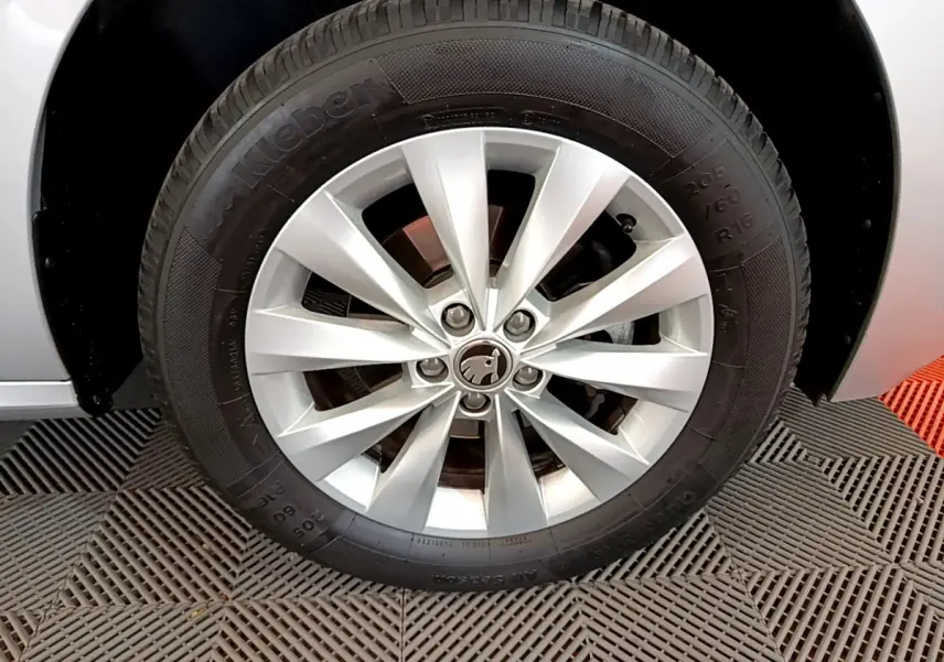 Gros plan sur la roue avant droite gris clair du Skoda Kamiq 2022 avec jante alliage et logo central visible.