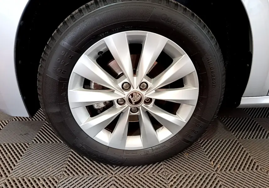 Gros plan sur la roue avant gauche gris clair d’un Skoda Kamiq 1.0 TSI 110ch DSG7 Business avec jante alliage à 10 branches.