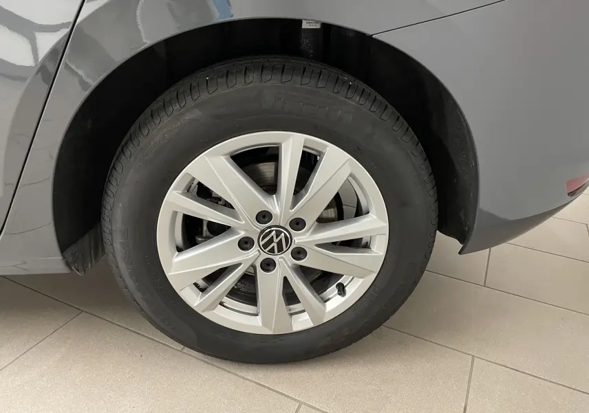 Gros plan sur la roue arrière droite du Volkswagen Touran gris Dauphin 2024 avec jante alliage et pneu Pirelli.