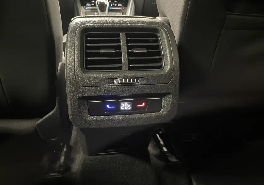 Vue rapprochée des commandes de climatisation arrière dans l'habitacle noir du Volkswagen Touran Gris Dauphin 2024.