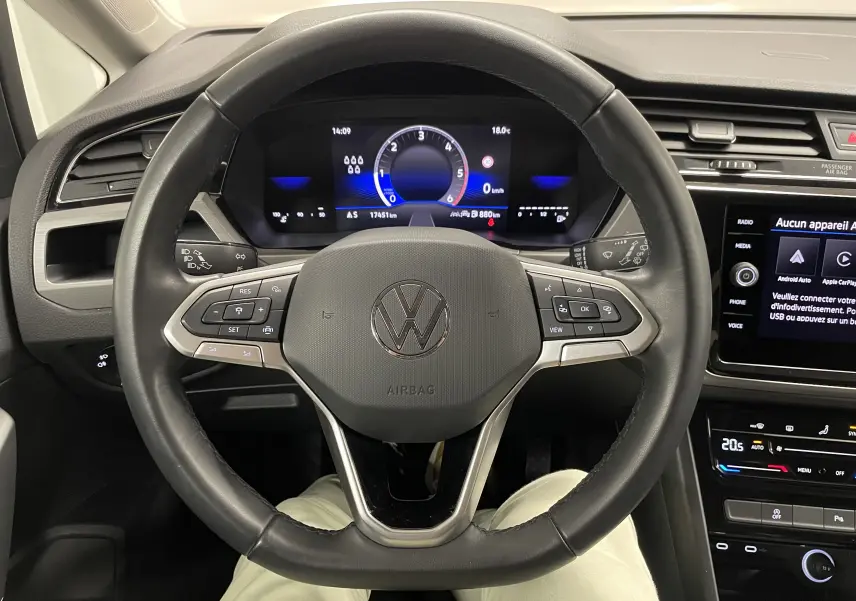 Vue centrée sur le volant du Volkswagen Touran 2024 avec tableau de bord numérique et commandes intégrées.