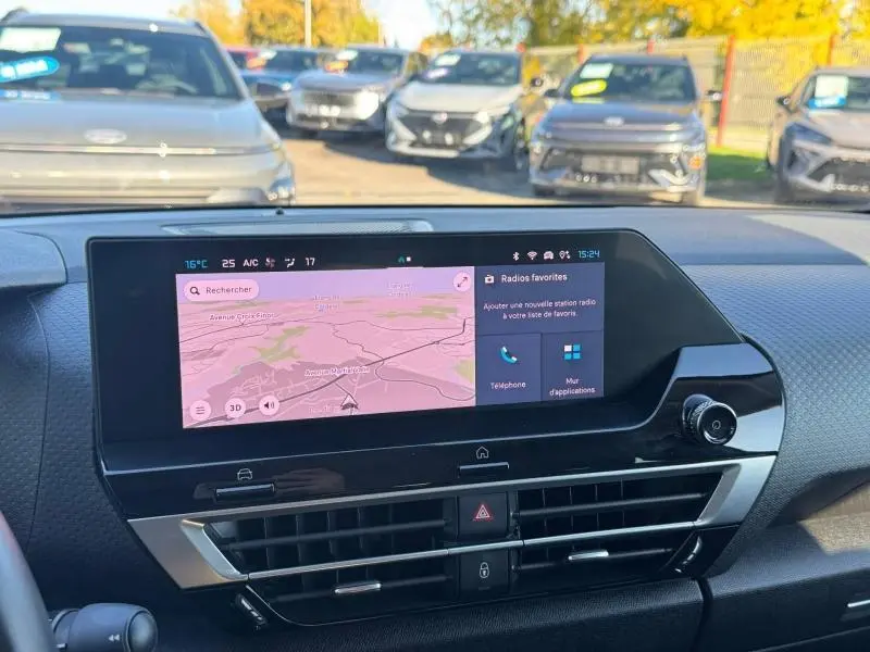 Vue intérieure du tableau de bord de la Citroën C4 2024 gris, avec écran tactile affichant la navigation et les radios favorites.