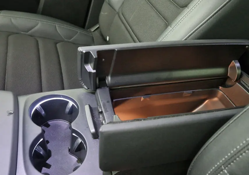 Vue rapprochée de l'accoudoir central noir ouvert et des porte-gobelets entre les sièges avant du Citroën C5 Aircross.