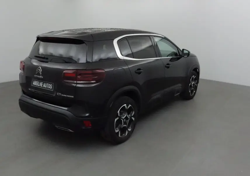 Citroën C5 Aircross noir vue 3/4 arrière droit, avec jantes stylées et contours de vitres chromés.