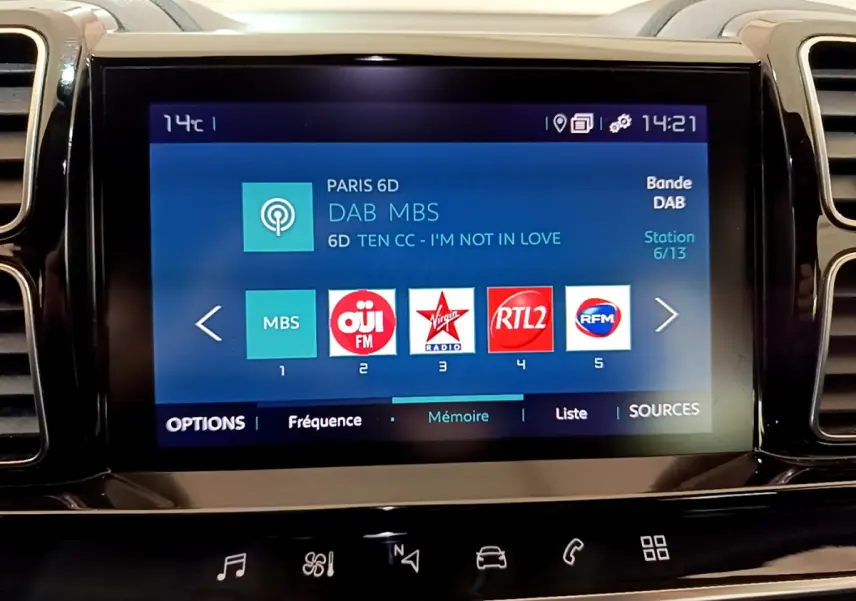 Écran tactile central affichant les stations radio numériques dans l'habitacle du Citroën C5 Aircross Hybrid gris clair.