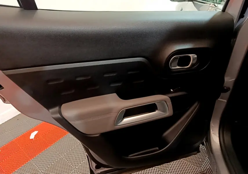 Gros plan sur la porte arrière droite gris clair du Citroën C5 Aircross Hybrid avec poignée argentée et garniture noire.