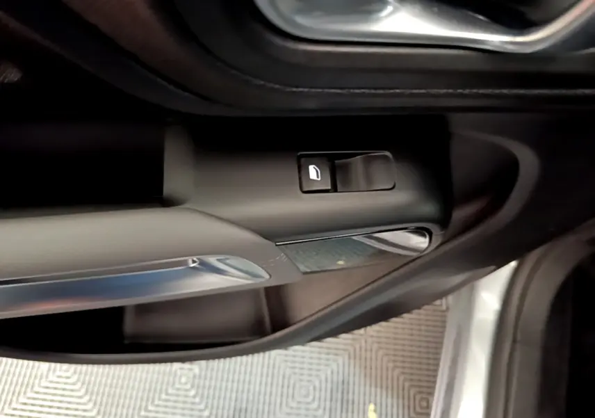 Détail de la commande d'ouverture de porte côté conducteur d'une Citroën C5 Aircross Hybrid gris clair de 2021.