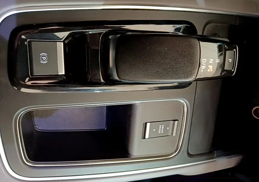 Gros plan sur la console centrale noire du Citroën C5 Aircross Hybrid 225 ë-EAT8 avec levier de vitesses automatique et bouton Drive Mode.