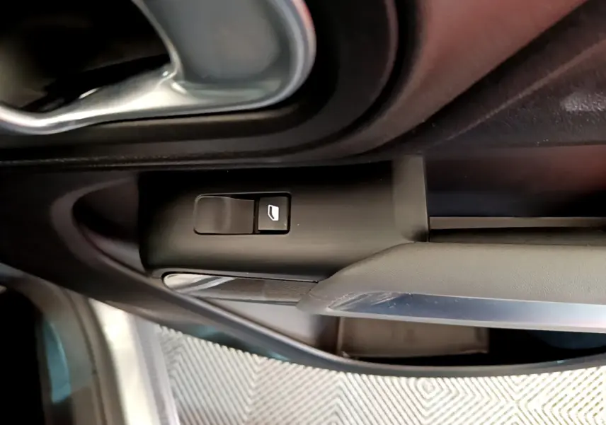 Détail de la commande de lève-vitre côté conducteur dans l'habitacle gris clair du Citroën C5 Aircross Hybrid 225 ë-EAT8 Business.