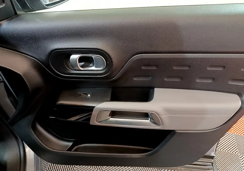 Détail de la porte côté gauche du Citroën C5 Aircross Hybrid 225 ë-EAT8 Business 2021 en gris clair, intérieur noir et gris.