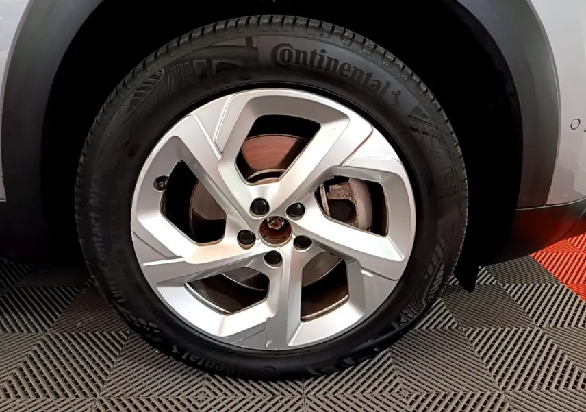 Gros plan sur la roue avant droite du Citroën C5 Aircross Hybrid gris clair, avec jante en alliage et pneu Continental.