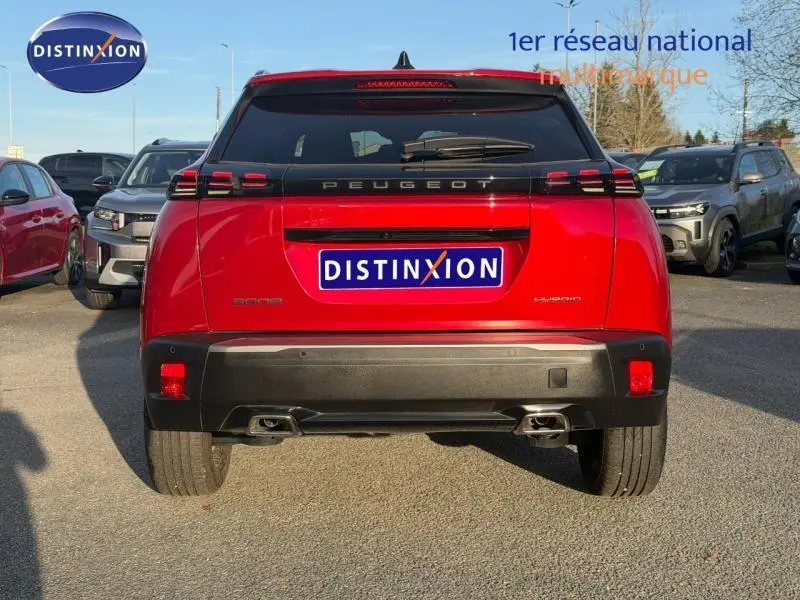 Vue arrière d'un Peugeot 2008 rouge Elixir avec feux LED et double sortie d'échappement chromée, stationné en extérieur.
