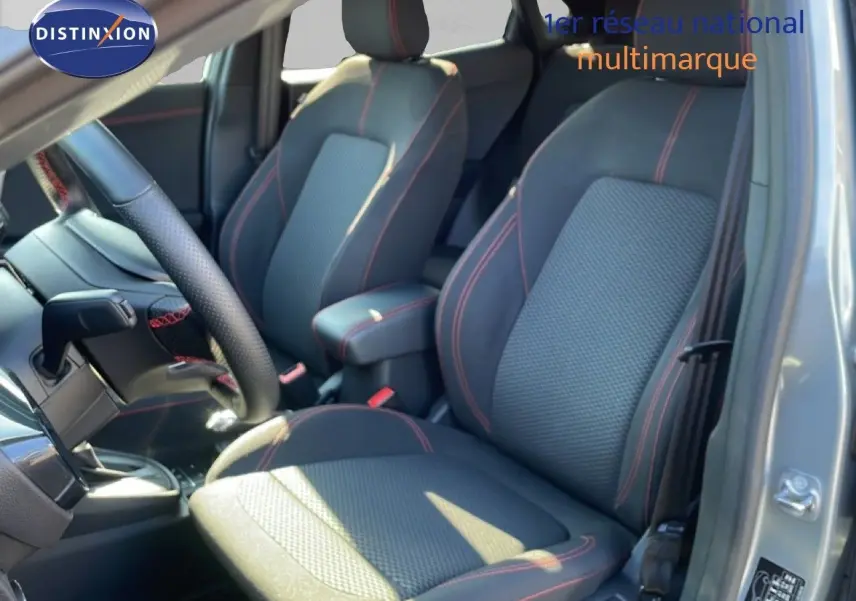 Vue intérieure côté conducteur du Ford Puma gris Solar Metal, sièges tissu noir avec surpiqûres rouges et volant cuir.