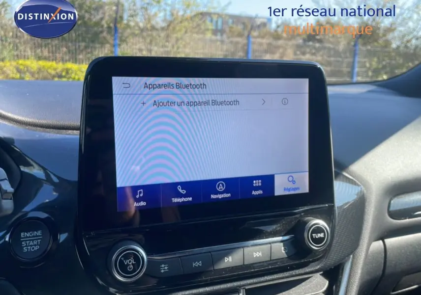 Vue rapprochée de l’écran tactile central du Ford Puma gris Solar Metal, affichant le menu Bluetooth en extérieur.