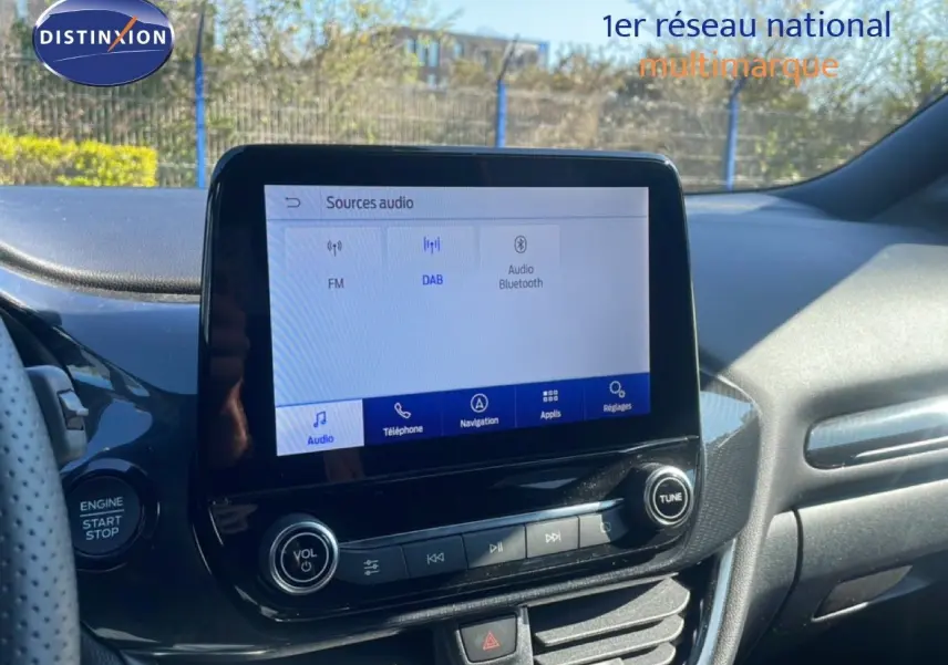 Vue intérieure du tableau de bord du Ford Puma 2023, avec écran tactile central affichant les sources audio.