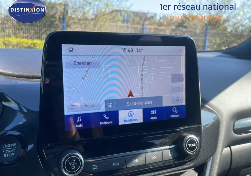 Vue rapprochée de l’écran tactile central du Ford Puma gris Solar Metal, affichant la navigation GPS sur fond extérieur lumineux.