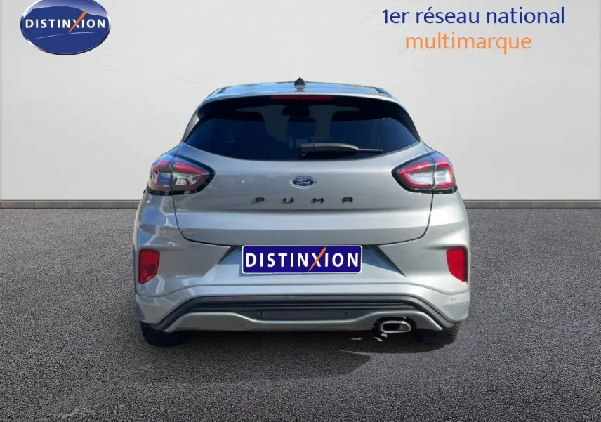 Vue arrière d'un Ford Puma gris Solar Metal 2023 avec feux distinctifs et sortie d'échappement chromée côté droit.