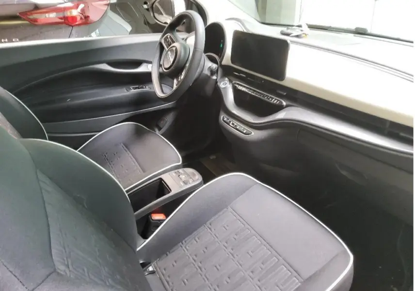 Vue 3/4 avant droite d'une Fiat 500 électrique blanche avec logo distinctif et jantes alliage multibranches.