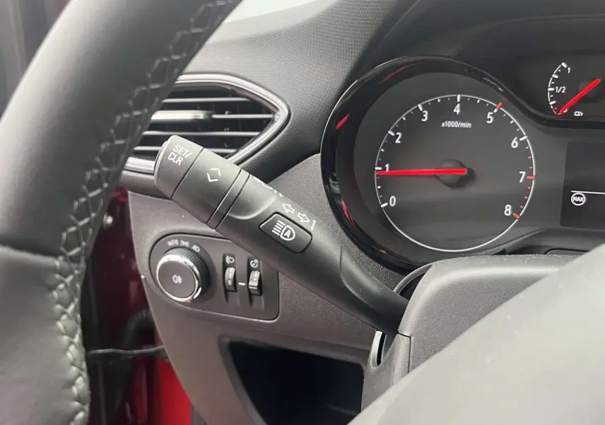 Gros plan sur le commodo de clignotant et le compte-tours du tableau de bord d'une Opel Crossland rouge de 2022.