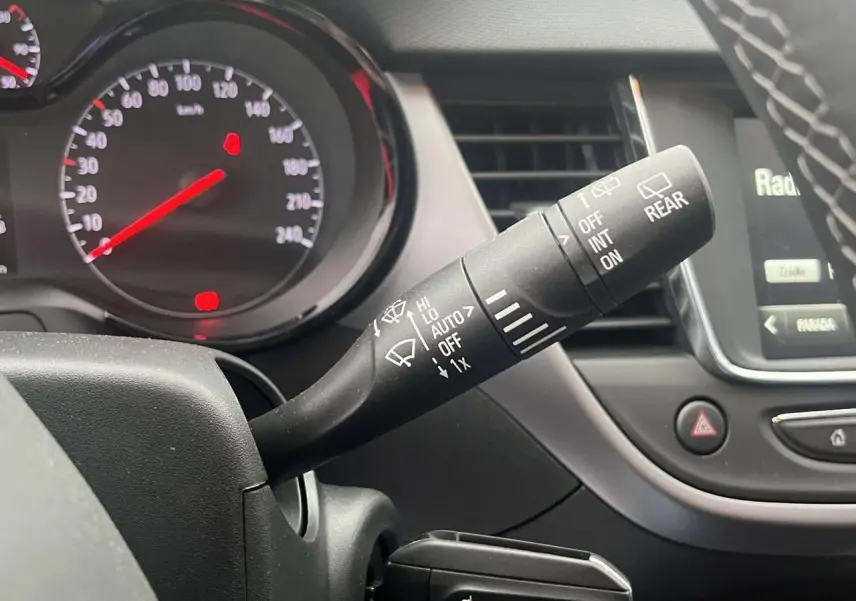 Gros plan sur la commande d’essuie-glace à droite du volant dans l’habitacle de l’Opel Crossland rouge 2022.
