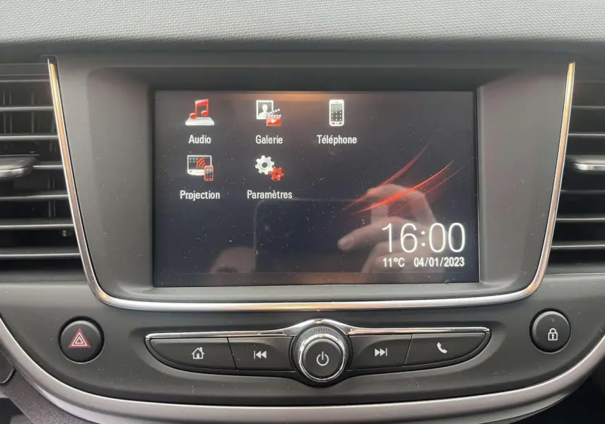 Écran tactile central du système multimédia de l'Opel Crossland rouge, affichant les options audio et téléphone.