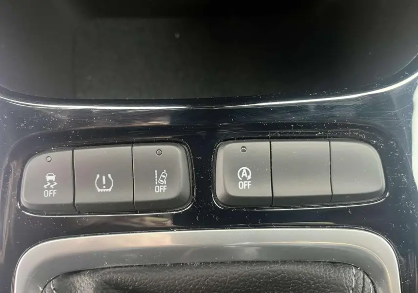 Gros plan sur les boutons de commande du système d'assistance et arrêt automatique du moteur de l'Opel Crossland 2022.