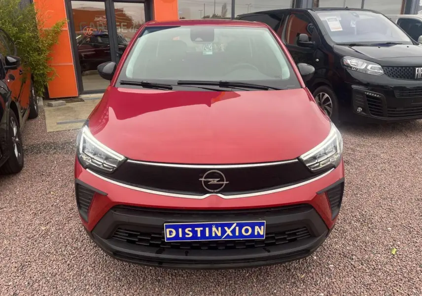 Vue frontale d'un Opel Crossland rouge métallisé 2022 avec calandre noire et phares LED distinctifs.
