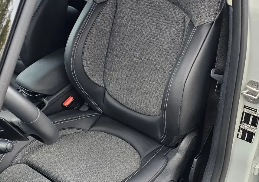 Gros plan sur le siège conducteur en tissu gris et cuir noir du MINI Cooper S Clubman 2022, porte ouverte côté gauche.