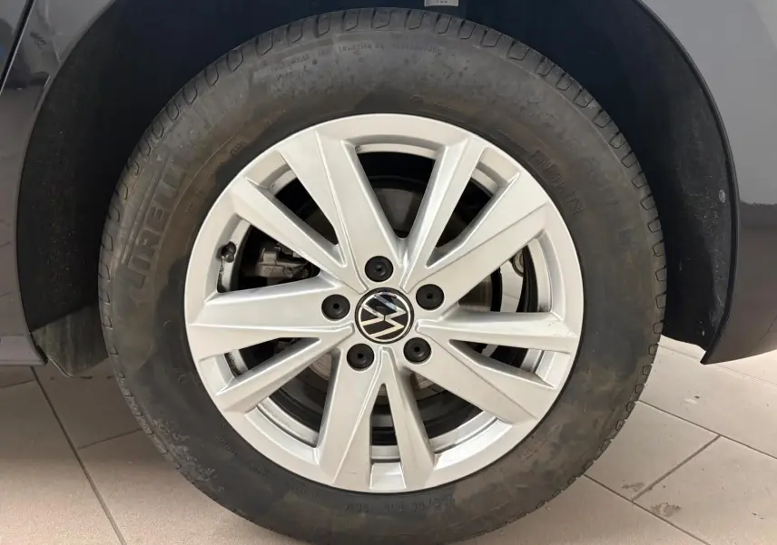 Gros plan sur la roue avant gauche du Volkswagen Touran 2024 noir intense nacré avec jante alliage à 10 branches.