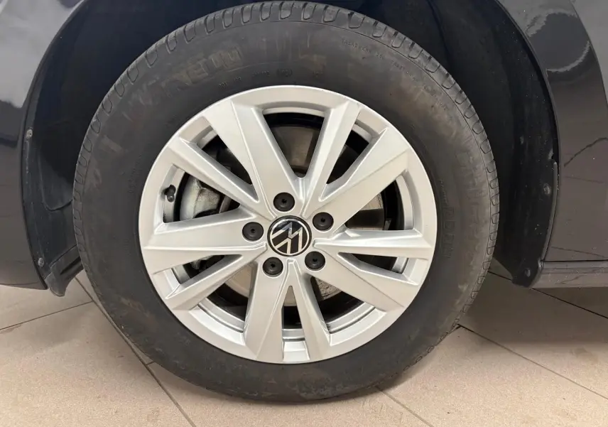 Gros plan sur la roue avant gauche du Volkswagen Touran noir intense nacré, avec jante alliage à 10 branches fines.