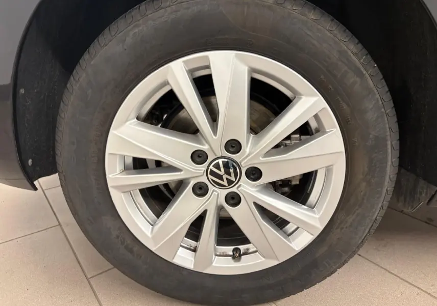 Gros plan sur la jante alliage argentée du Volkswagen Touran Noir Intense nacré, roue avant droite visible.