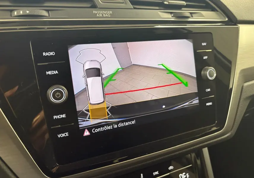 Écran central du Volkswagen Touran 2024 affichant la caméra de recul avec guidage de trajectoire en intérieur noir nacré.
