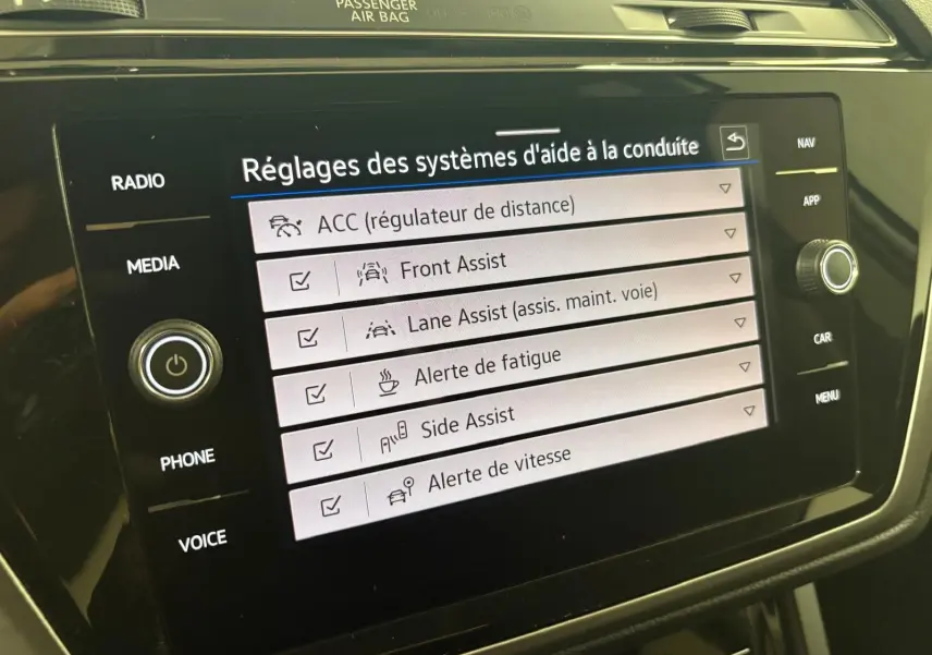 Écran tactile du système d'infodivertissement Volkswagen Touran 2024 affichant les réglages d'aide à la conduite.