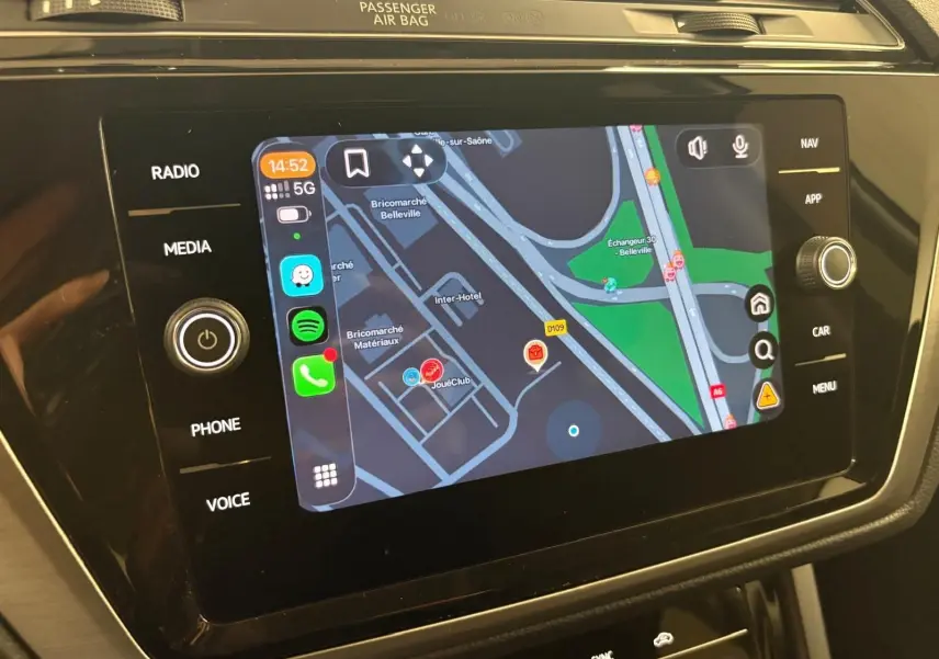 Écran tactile central du Volkswagen Touran 2024 affichant la navigation avec interface connectée, ambiance intérieure noire.