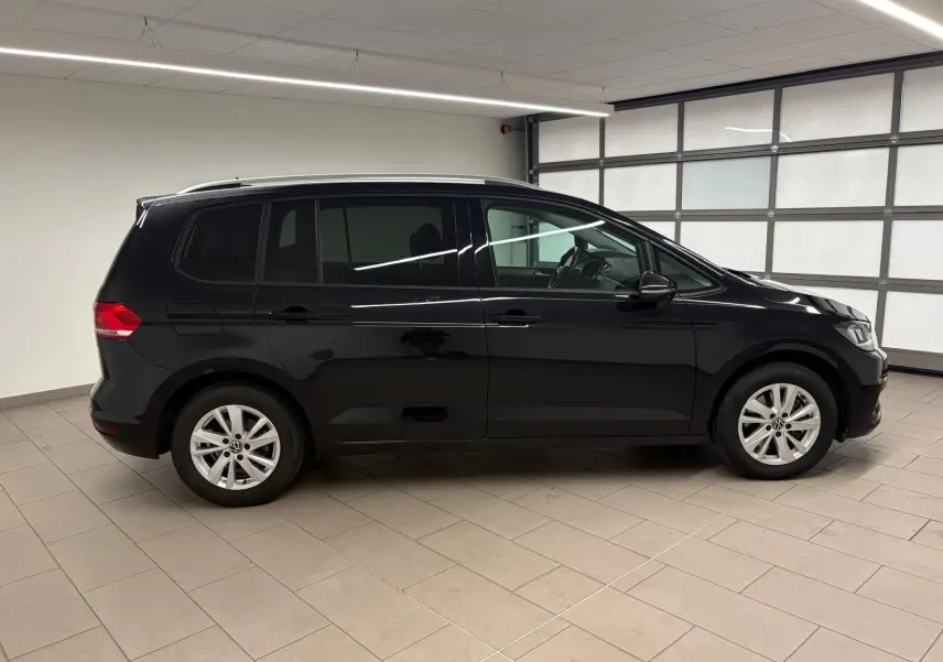 Profil droit d'un Volkswagen Touran noir intense nacré 2024, montrant ses lignes épurées et ses jantes alliage.