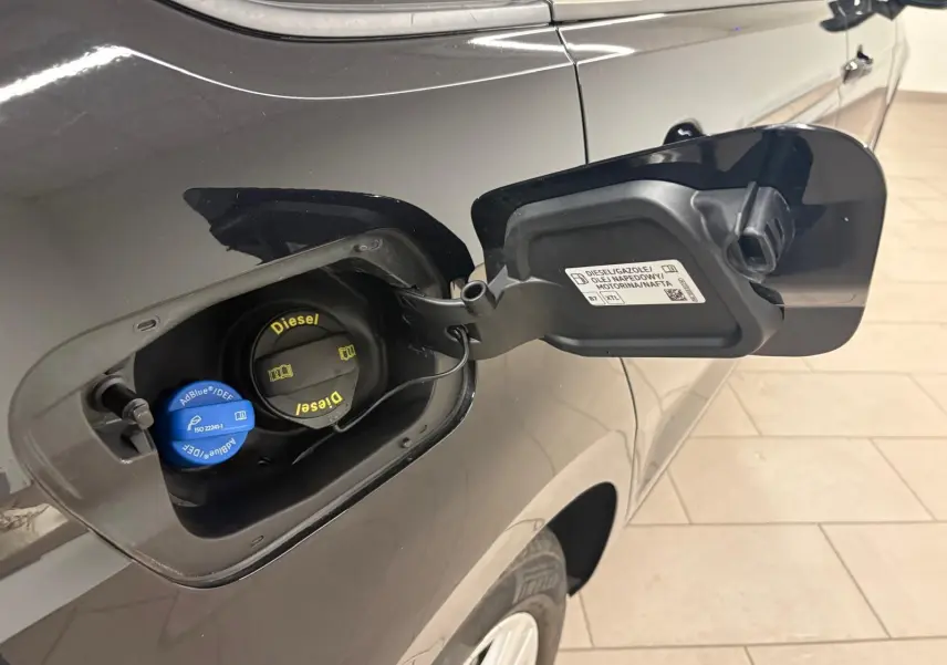 Bouchon de réservoir diesel ouvert côté gauche d'un Volkswagen Touran noir intense nacré 2024, détail carburant et AdBlue visible.