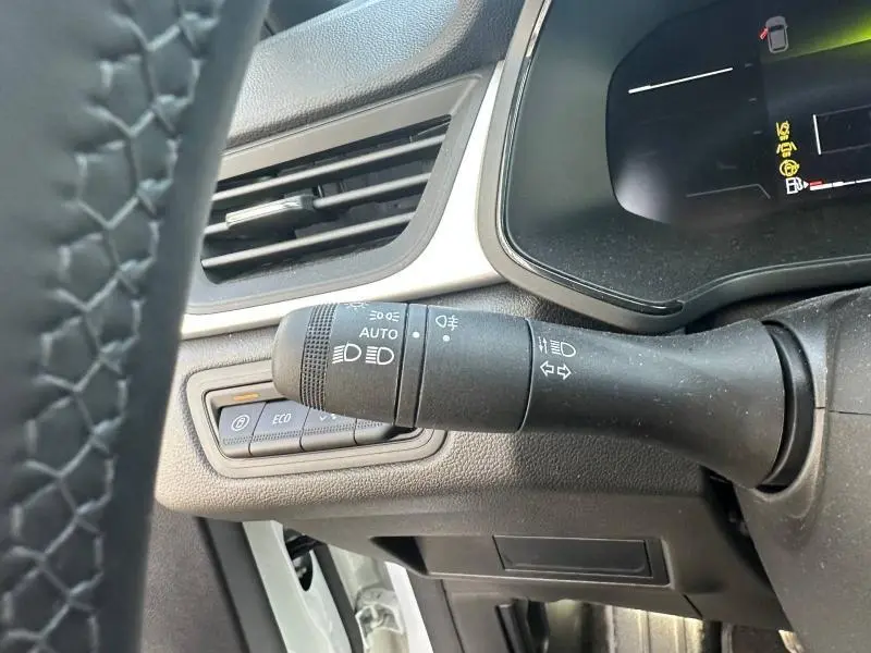 Gros plan sur la commande des phares et clignotants à gauche du volant dans un Renault Captur blanc nacré 2025.