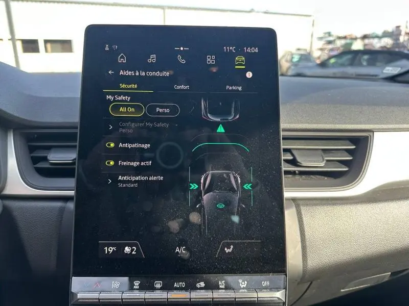 Écran tactile central du Renault Captur 2025 montrant les aides à la conduite, avec tableau de bord gris clair en arrière-plan.