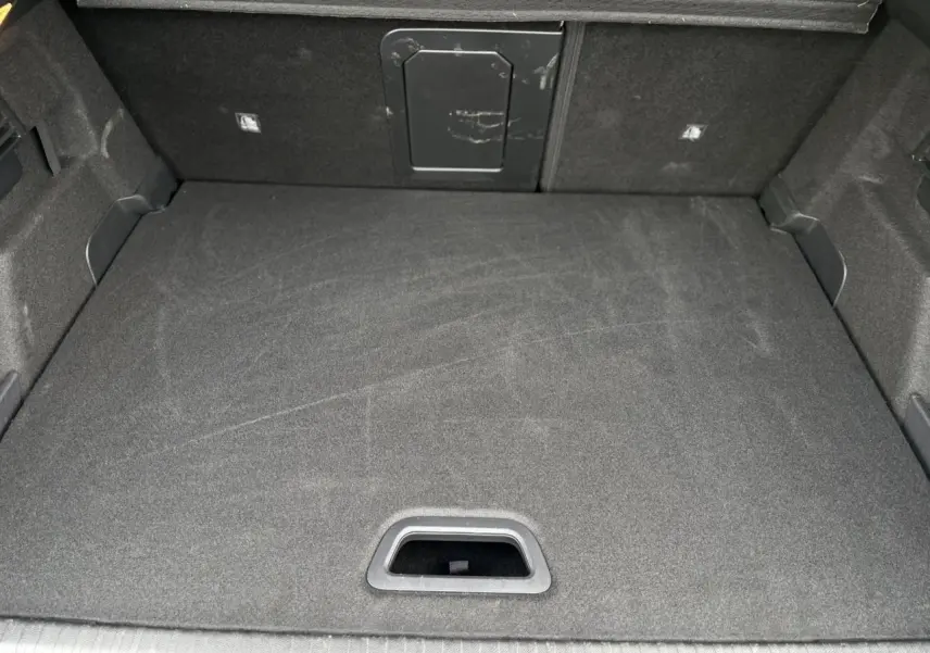 Vue intérieure du coffre spacieux et tapissé de tissu gris foncé du Citroën C4 Hybrid 2025.