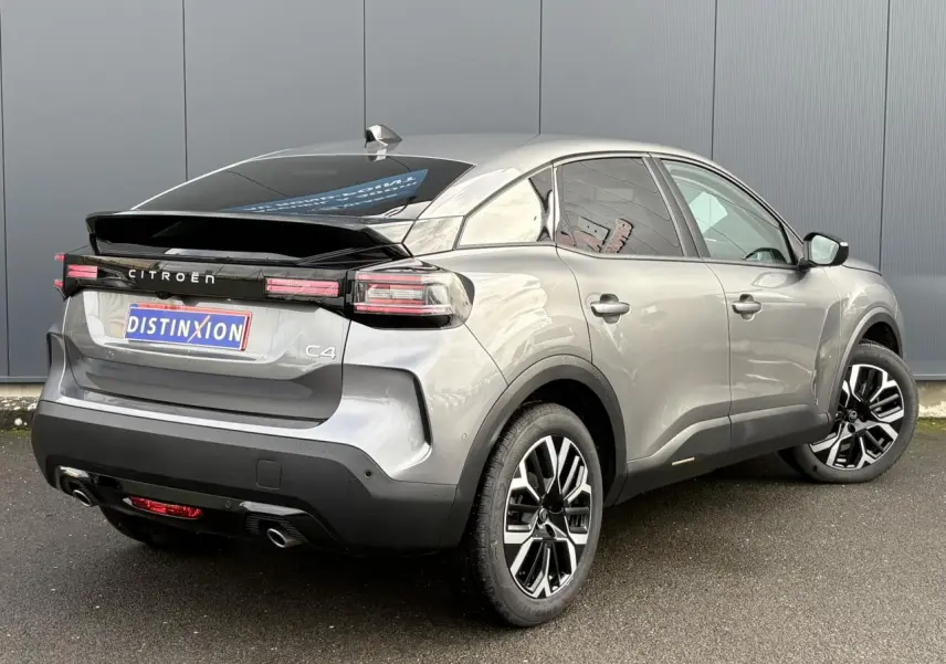 Vue 3/4 arrière droite d'une Citroën C4 gris Mercury avec jantes alliage 18'' et bandeau noir brillant arrière.