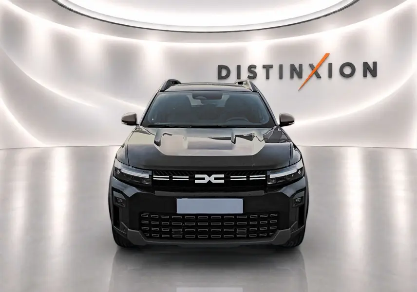 Vue avant d'un Dacia Bigster noir 2025 avec calandre marquée et barres de toit visibles en showroom lumineux.
