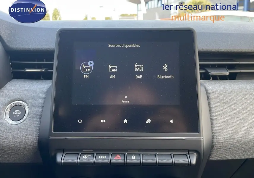 Écran tactile central affichant les sources audio dans l'habitacle gris de la Renault Clio 1.5 DCI 2025.