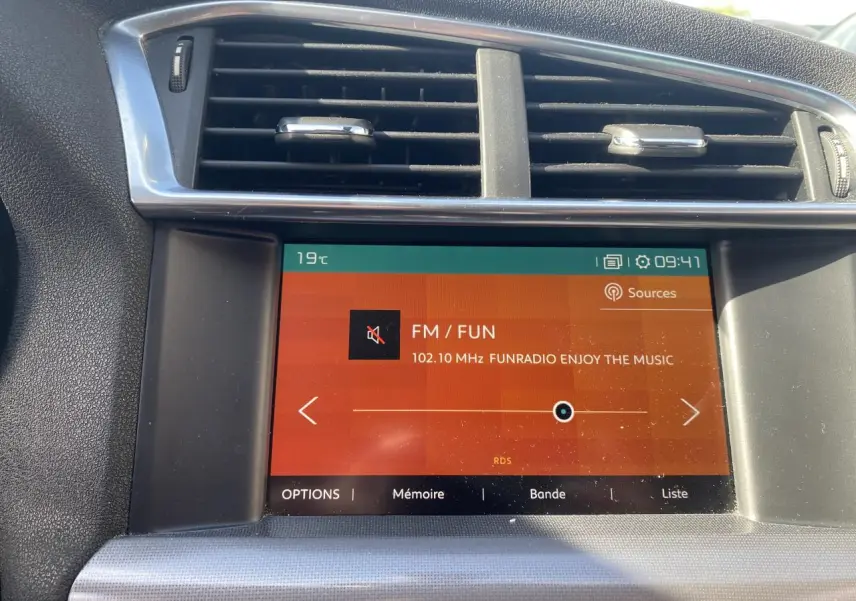 Écran tactile central de la Citroën C4 gris platinium 2017 affichant la radio FM vue de face.