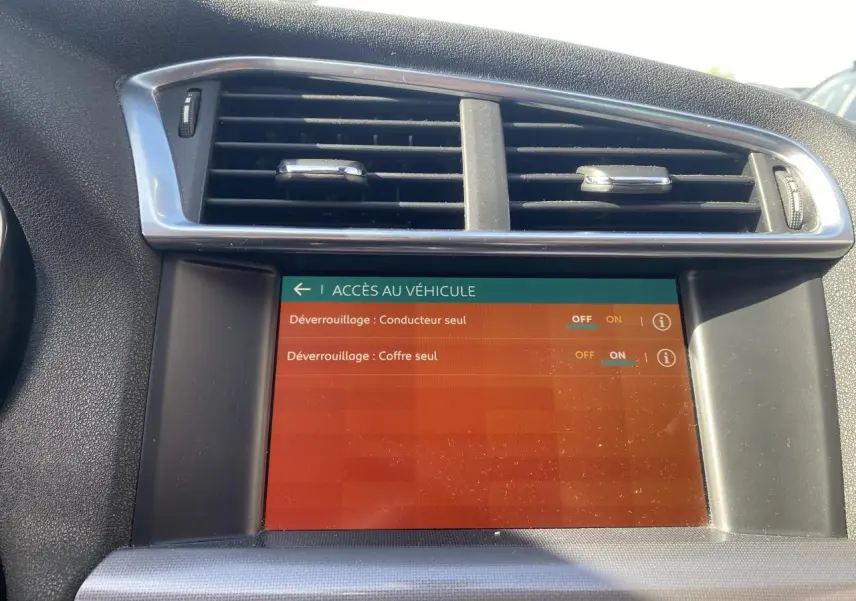 Écran tactile central de la Citroën C4 2017 montrant les options de déverrouillage, entouré de la console noire et grise.