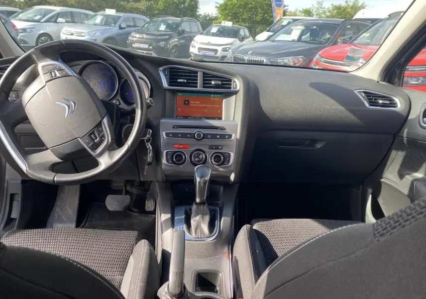 Intérieur de Citroën C4 2017 vu de face, tableau de bord noir avec écran tactile et volant multifonction.