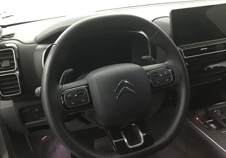 Volant en cuir noir de Citroën C5 Aircross 2024 avec commandes intégrées, tableau de bord et écran tactile visibles.