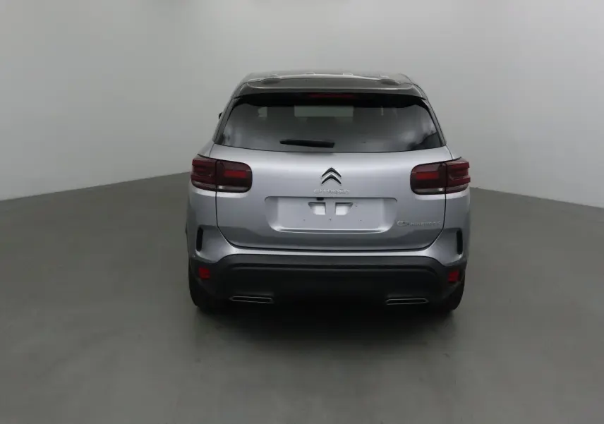 Vue arrière d'un Citroën C5 Aircross gris Artense avec toit noir, feux arrière foncés et double sortie d'échappement intégrée.