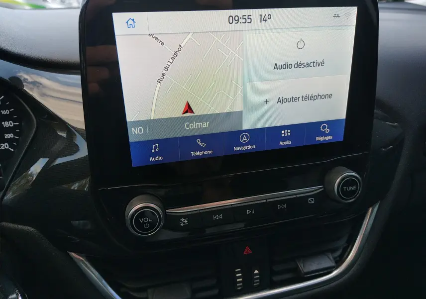 Vue rapprochée de l'écran tactile central avec navigation et commandes audio dans le Ford Puma blanc 2021.