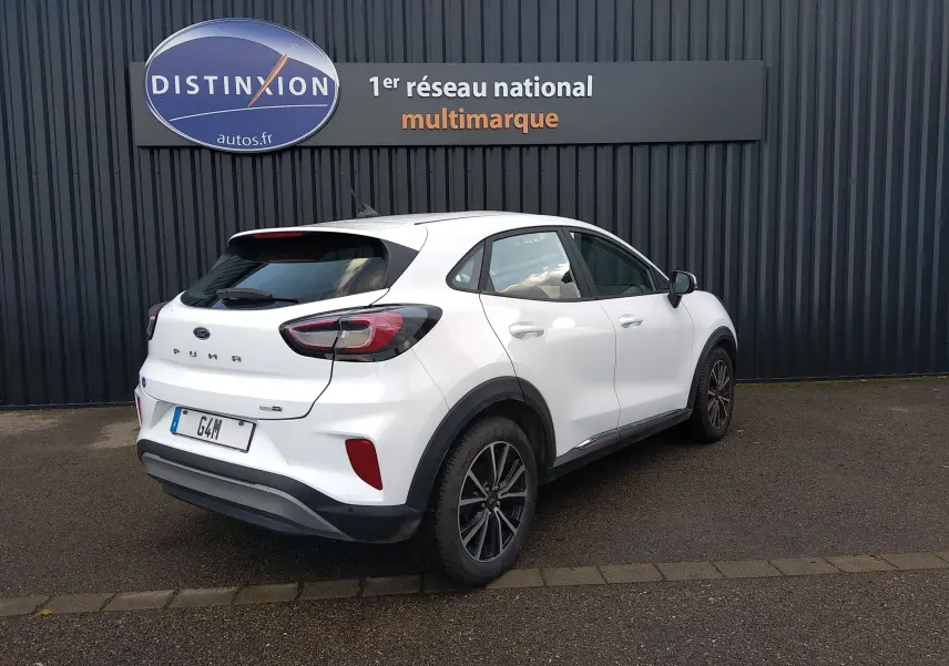 Ford Puma blanc en 3/4 arrière droit, soulignant ses feux arrière distinctifs et ses jantes noires bicolores.